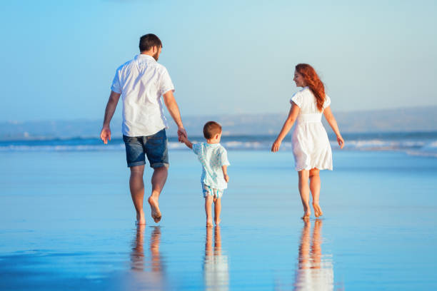 istock Family walking by sunset beach 1144806871