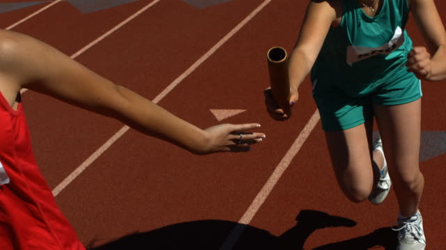 Baton pass in a track relay, slow motion