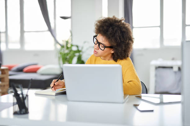 istock Businesswoman taking notes while sitting in office. 1144810835