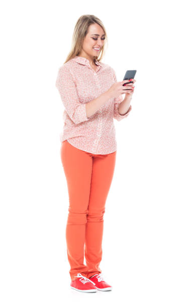 istock Good looking white female standing on white background - texting on smart phone 1144810881
