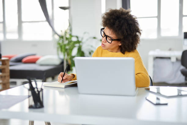 istock Businesswoman taking notes while sitting in office. 1144811072