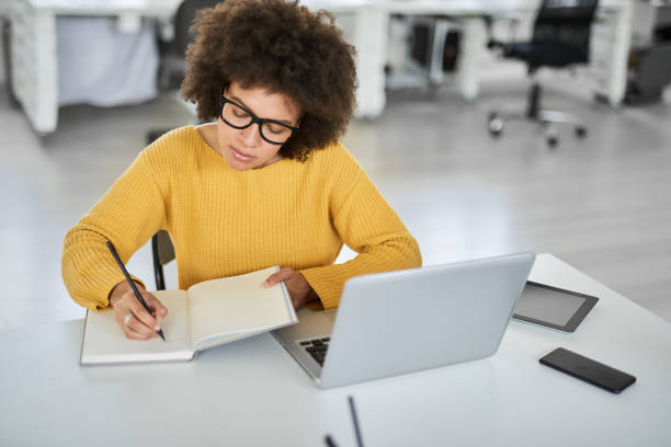 istock Businesswoman taking notes while sitting in office. 1144811077