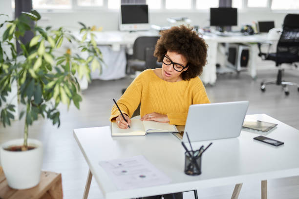 istock Businesswoman taking notes while sitting in office. 1144811965