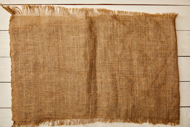 istock piece of brown sackcloth on white wooden surface 1144812176