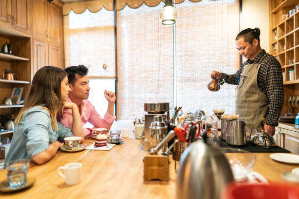 istock Coffee shop owner making coffee for young couple 1144812269