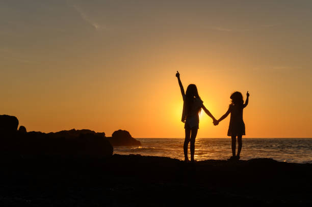happy little girl travel in mountains at sunset near sea, kid enjoy hiking in nature