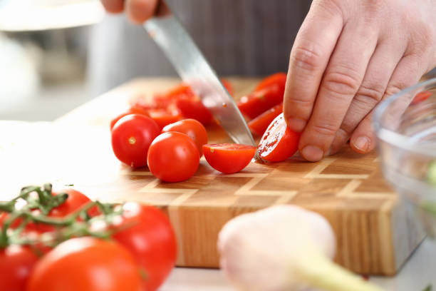 istock Male Hands Slicing Ripe Cherry Tomato Ingredient 1144814449