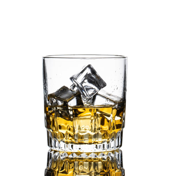 istock Whiskey Glass closeup, white background, with many ice cubes falling and splashing 1144815568