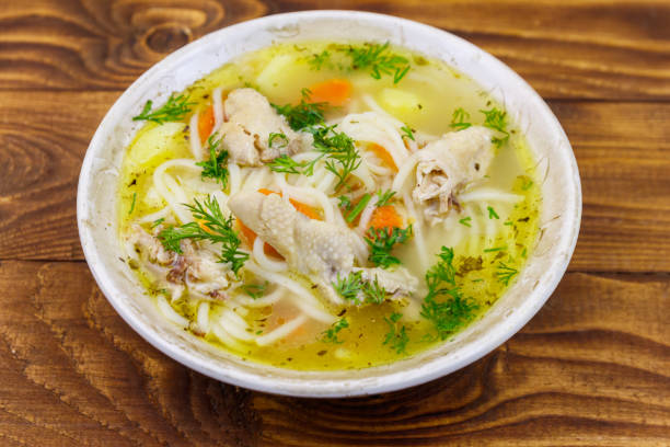 istock Chicken soup with noodles and vegetables on wooden table 1144820919