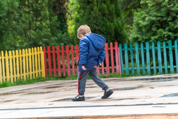 Small child scratching his bottom at a park stock photo