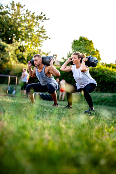 大人の男性と女性の体重トレーニング屋外 - crossfit exercising sports training outdoors ストックフォトと画像