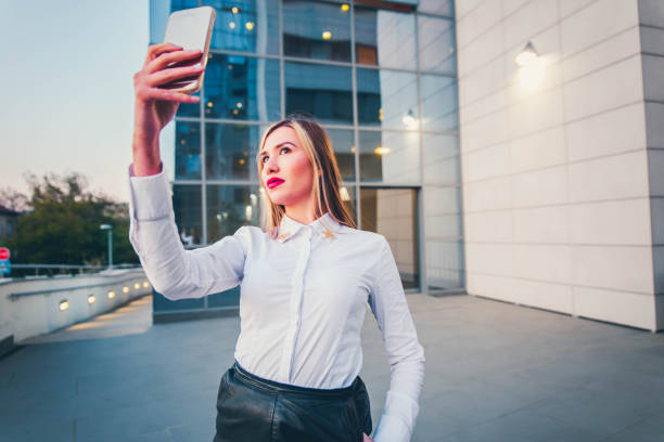 istock Business woman taking selfie in front office building 1144822927