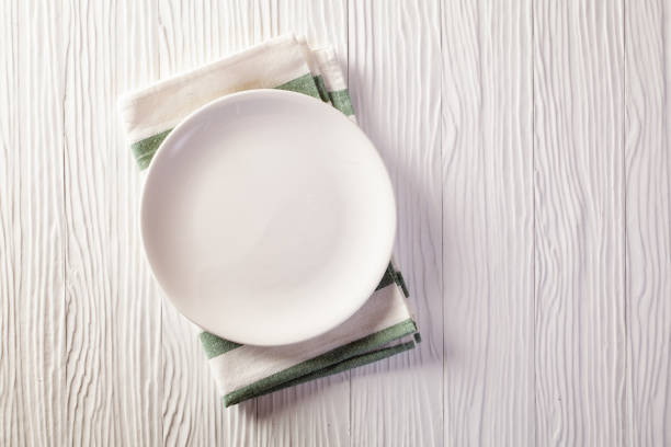 istock Empty plate on checkered tablecloth on white wooden table 1144823479
