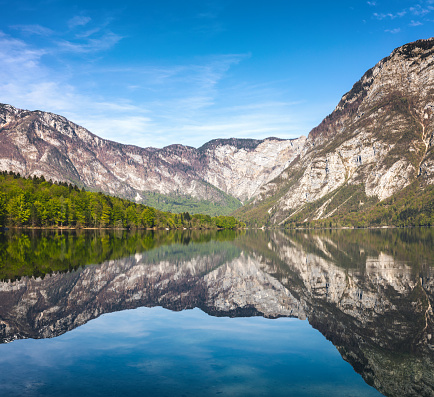 Beautiful spring day at Lake Bohinj, Slovenia. Mountains are reflecting in the water.