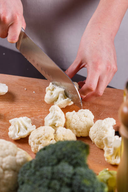 istock young woman in a gray aprons cuts cauliflower broccoli 1144826440