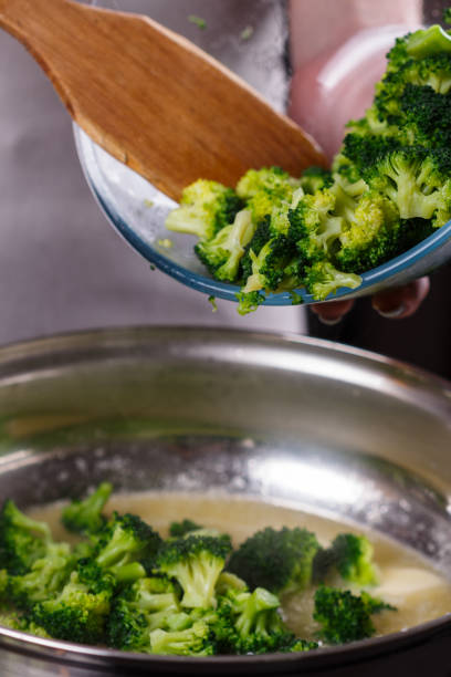 istock young woman in a gray apron roasts cauliflower broccoli 1144826491