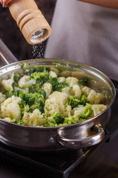 istock young woman in a gray apron roasts cauliflower broccoli 1144826568