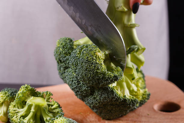 istock young woman in a gray aprons cuts cauliflower broccoli 1144826677