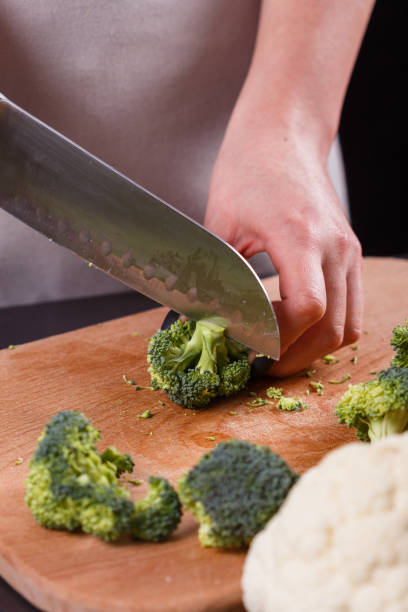 istock young woman in a gray aprons cuts cauliflower broccoli 1144826723