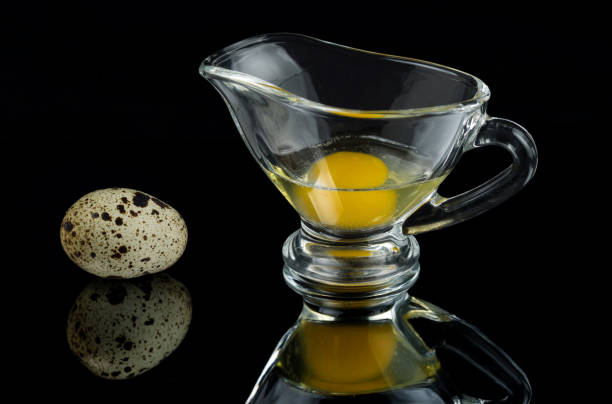 istock Quail eggs in the shell and in a glass gravy boat on a black mirror surface 1144830741