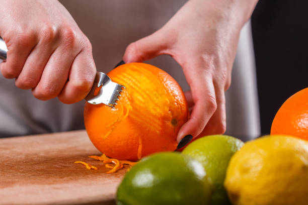 istock young woman in a gray aprons, cuts an orange zest 1144830833