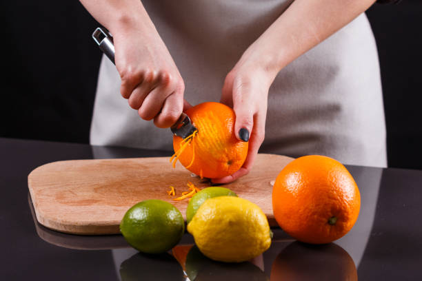 istock young woman in a gray aprons, cuts an orange zest 1144830841