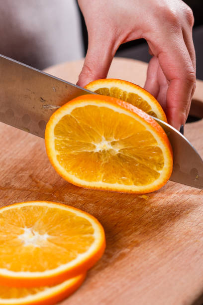 istock young woman in a gray aprons cuts an orange 1144830899