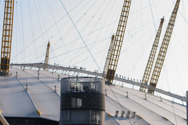 menschen klettern/wandern auf dem roof walk der o2 arena arena, einem stoffsteg, der von masten abgehängt ist. - millennium dome dome stadium nautical vessel stock-fotos und bilder