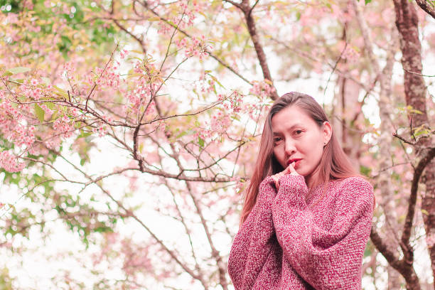 istock Women standing under the trees that bloom pink, 1144831544