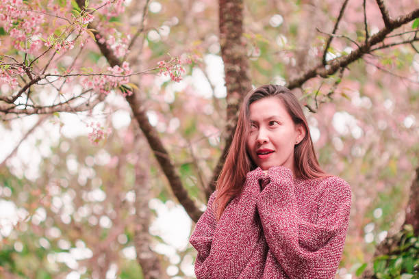 istock Women standing under the trees that bloom pink, 1144831598