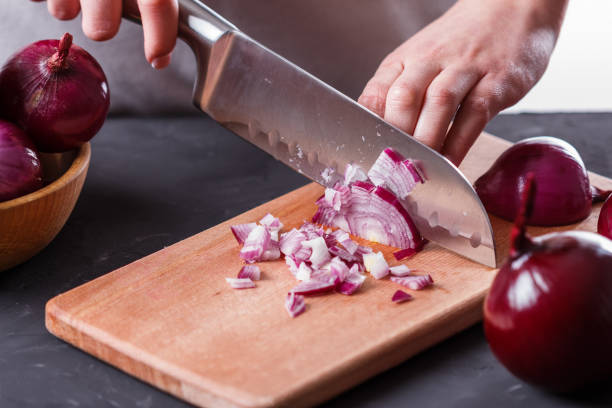 istock young woman in a gray aprons cuts red onion 1144834070