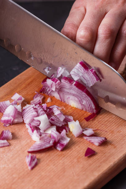 istock young woman in a gray aprons cuts red onion 1144834089