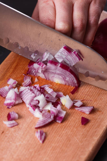 istock young woman in a gray aprons cuts red onion 1144834120