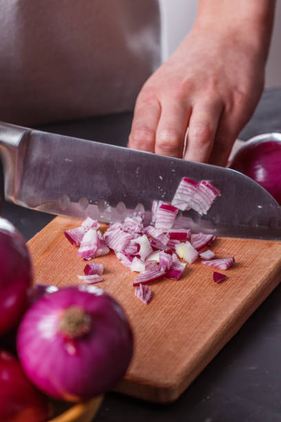 istock young woman in a gray aprons cuts red onion 1144834163