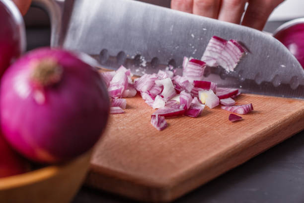 istock young woman in a gray aprons cuts red onion 1144834177