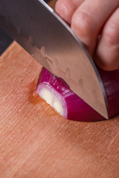 istock young woman in a gray aprons cuts red onion 1144834185
