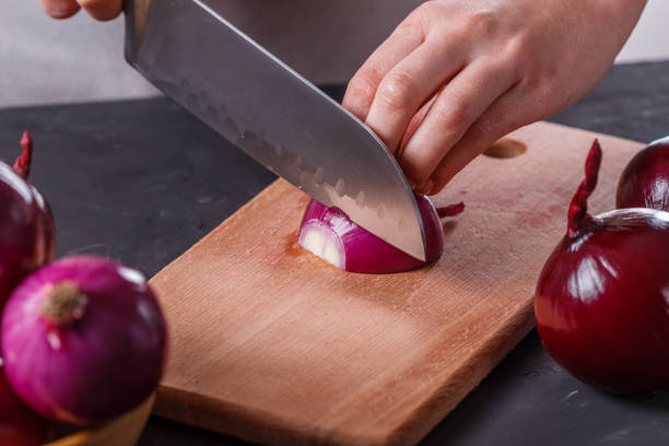 istock young woman in a gray aprons cuts red onion 1144834221