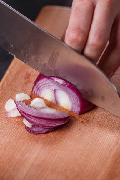 istock young woman in a gray aprons cuts red onion 1144834226