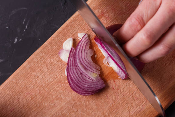 istock young woman in a gray aprons cuts red onion 1144834248