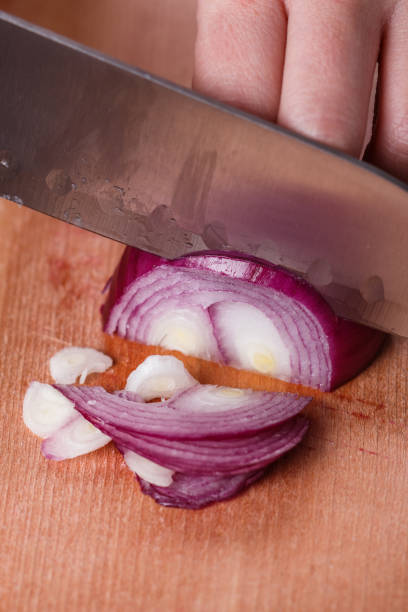 istock young woman in a gray aprons cuts red onion 1144834250