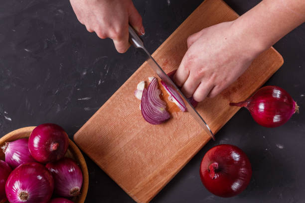 istock young woman in a gray aprons cuts red onion 1144834263
