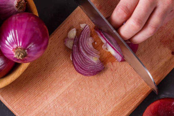 istock young woman in a gray aprons cuts red onion 1144834277