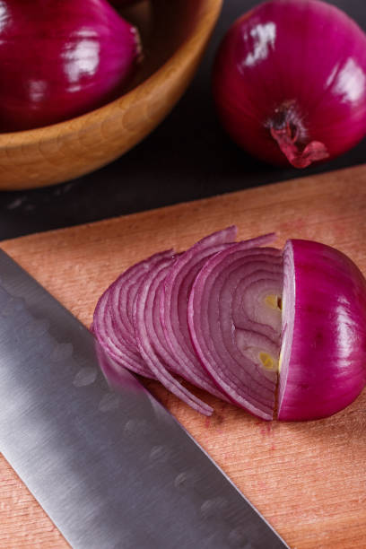 istock red onion cut on a wooden board 1144834403