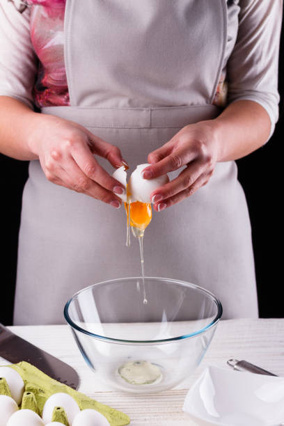 istock young woman in a gray aprons breaks the eggs 1144835608
