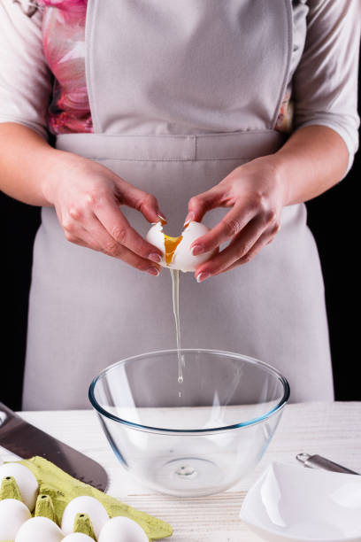 istock young woman in a gray aprons breaks the eggs 1144835615