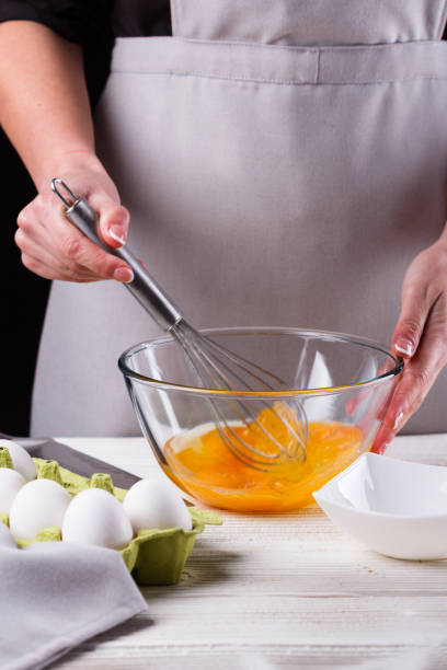 istock young woman in a gray aprons breaks the eggs 1144835640