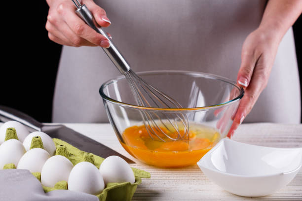 istock young woman in a gray aprons breaks the eggs 1144835650
