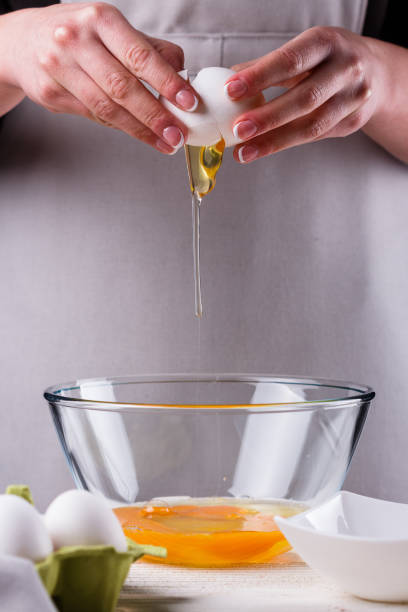 istock young woman in a gray aprons breaks the eggs 1144835660