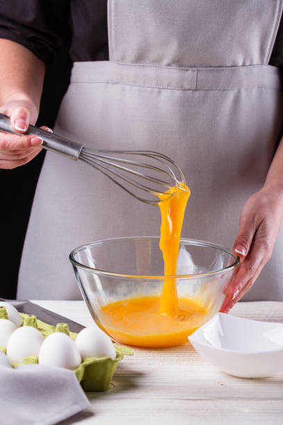 istock young woman in a gray aprons breaks the eggs 1144835689