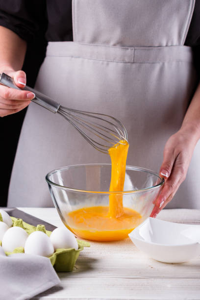 istock young woman in a gray aprons breaks the eggs 1144835700